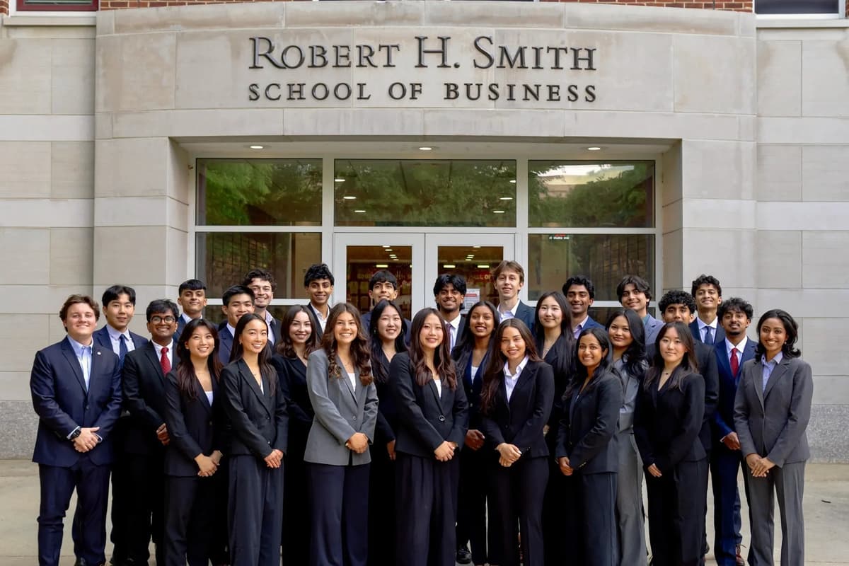 SCG members in business attire standing together in front of the Robert H. Smith School of Business.