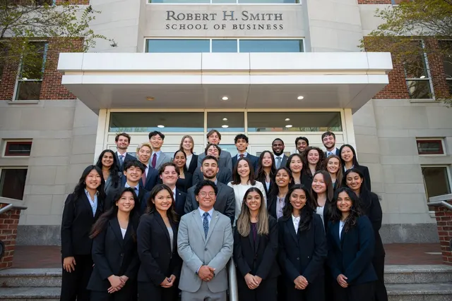 SCG members in business attire gathered on the front steps of the Robert H. Smith School of Business.